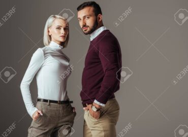 couple posing in fashionable autumn outfit, isolated on grey